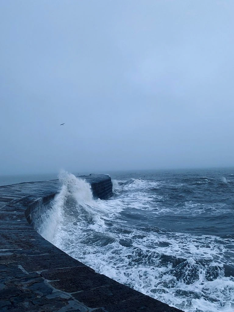 The curved Cobb breakwater meets the sea